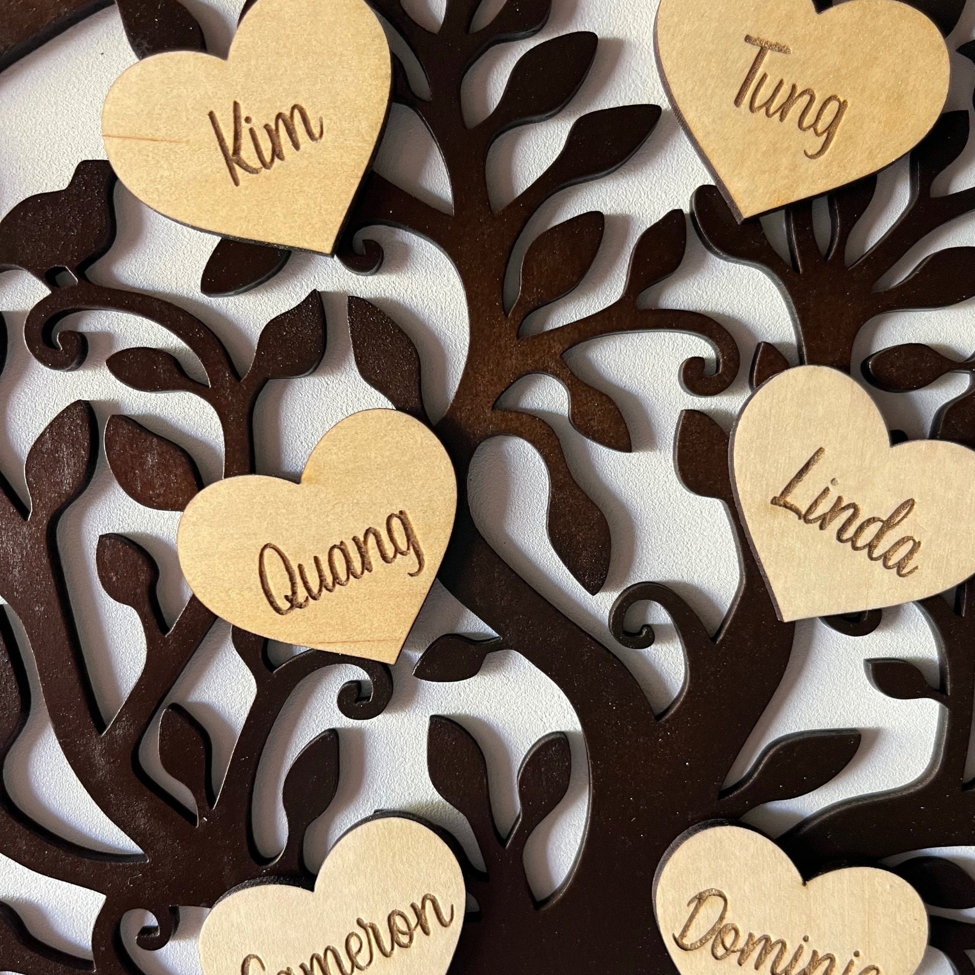 Heart-shaped wooden tags with names on a decorative family tree for custom family tree additions
